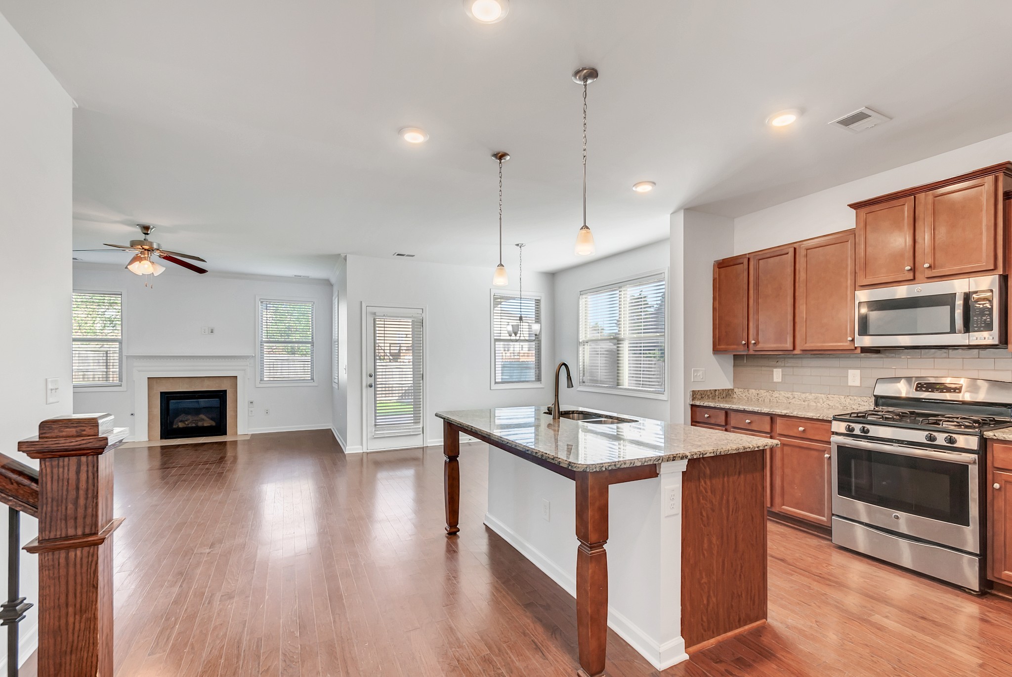 3005 Alan Drive Spring Hill, TN 37174 - Photo 12 of 41 a kitchen with stainless steel appliances granite countertop a stove a sink dishwasher a refrigerator and a fireplace with wooden floor