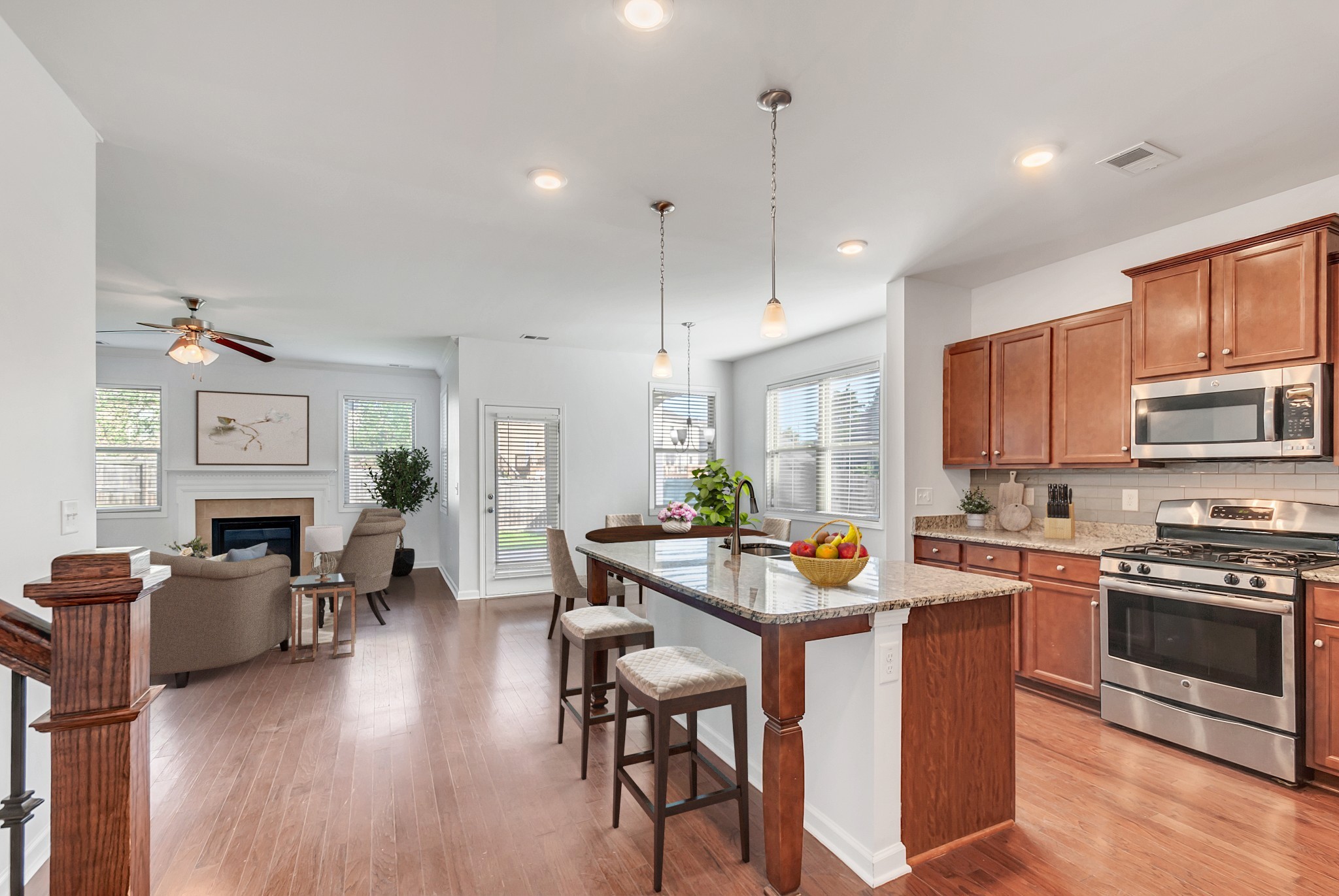 3005 Alan Drive Spring Hill, TN 37174 - Photo 3 of 41 a open kitchen with stainless steel appliances granite countertop a stove top oven a sink dishwasher a dining table and chairs with wooden floor