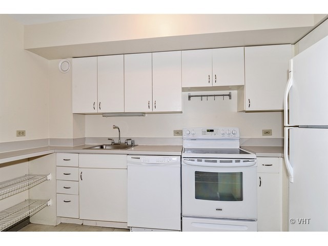 40 East 9th Street, Unit 804 Chicago, IL 60605 - Photo 3 of 16 a kitchen with granite countertop white cabinets and white appliances