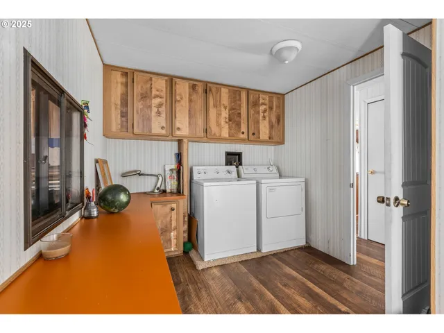 a view of a kitchen with a sink and dishwasher with wooden floor