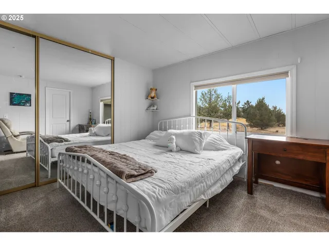 a bedroom with a bed and a large window