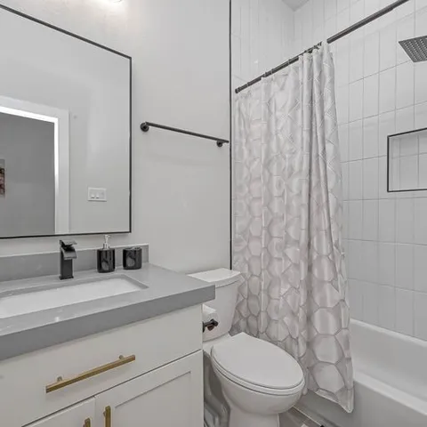 a spacious bedroom with a large bed and a chandelier fan