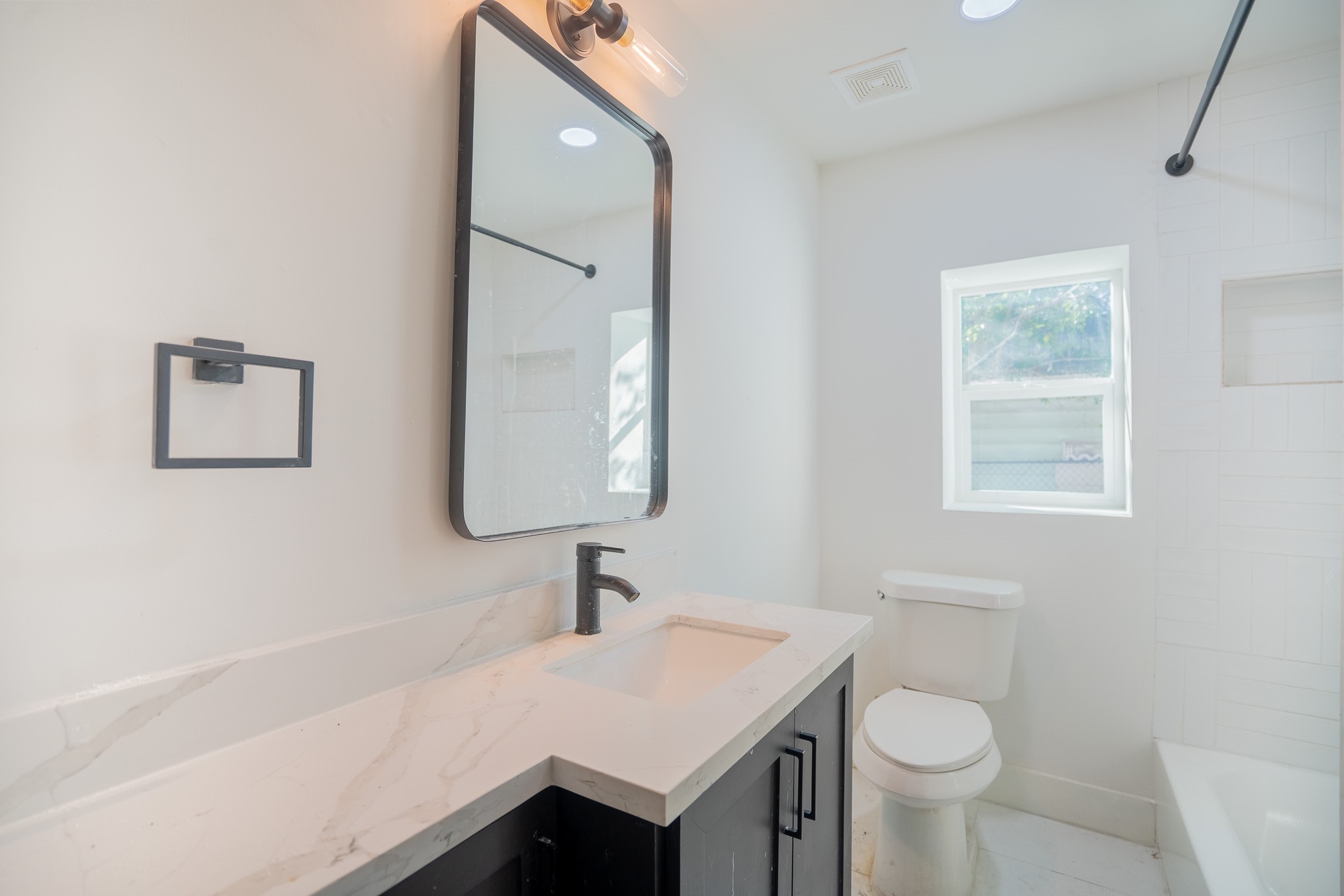 7305 Capitol Street Houston, TX 77011 - Photo 12 of 16 a bathroom with a sink toilet a mirror and vanity