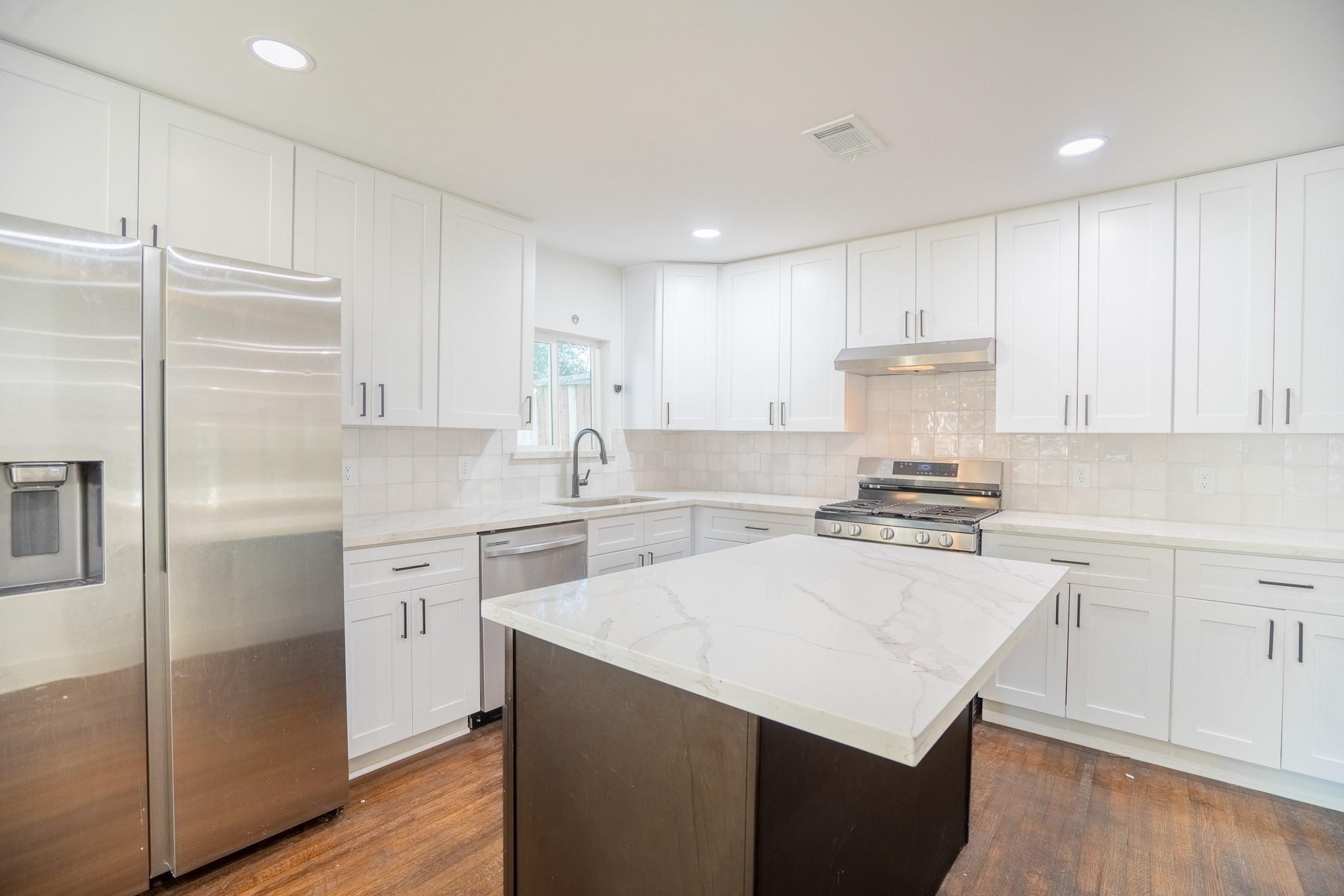 7305 Capitol Street Houston, TX 77011 - Photo 6 of 16 a kitchen with a sink a refrigerator and a stove top oven