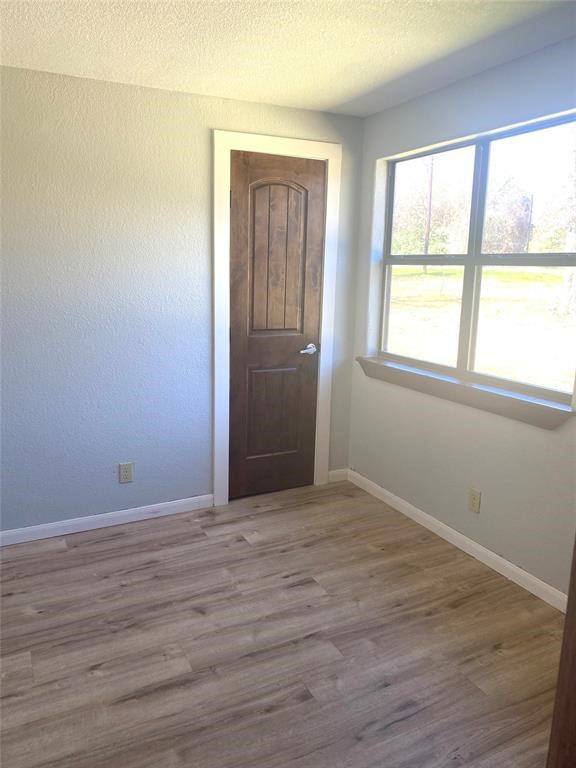 137 Road Runner Lane Bastrop, TX 78602 - Photo 11 of 18 an empty room with wooden floor and windows