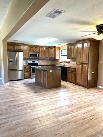 a kitchen with stainless steel appliances granite countertop a refrigerator and stove
