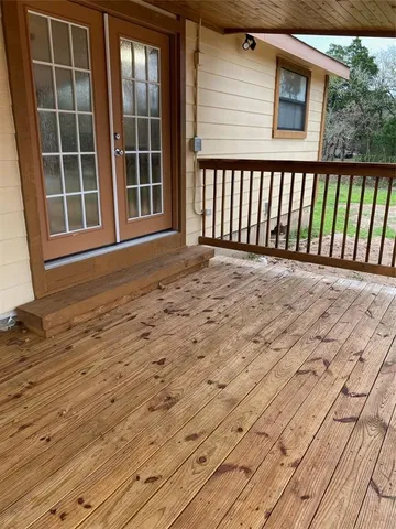 a view of an empty room with wooden floor and fence