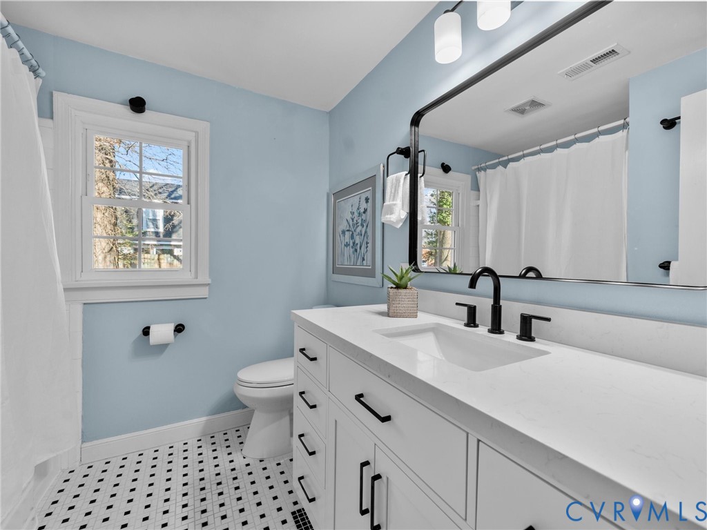 6715 Galaxie Road Henrico, VA 23228 - Photo 25 of 40 a bathroom with a sink a toilet a mirror a vanity and shower