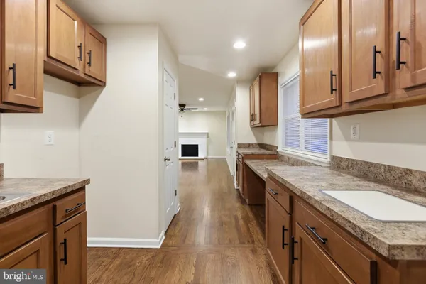 a kitchen with granite countertop a sink a stove oven and cabinets