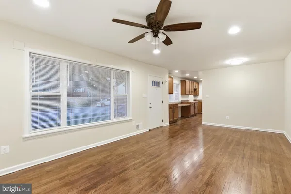 a view of an empty room with a window and wooden floor