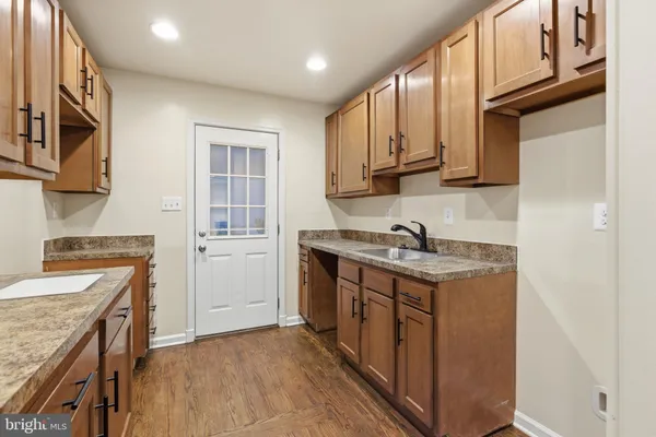 a kitchen with granite countertop a sink stove and cabinets