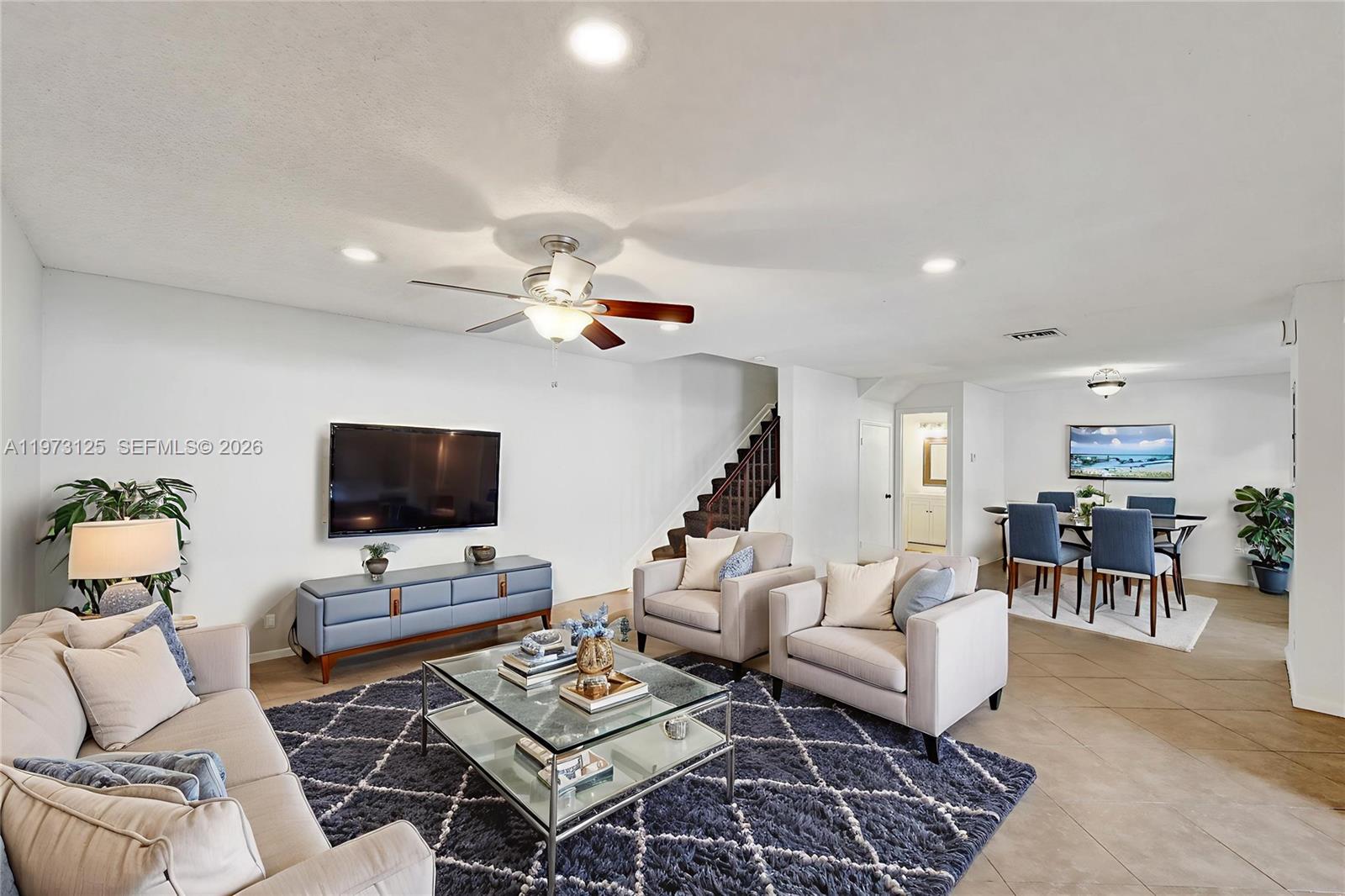 a living room with furniture a rug and a flat screen tv
