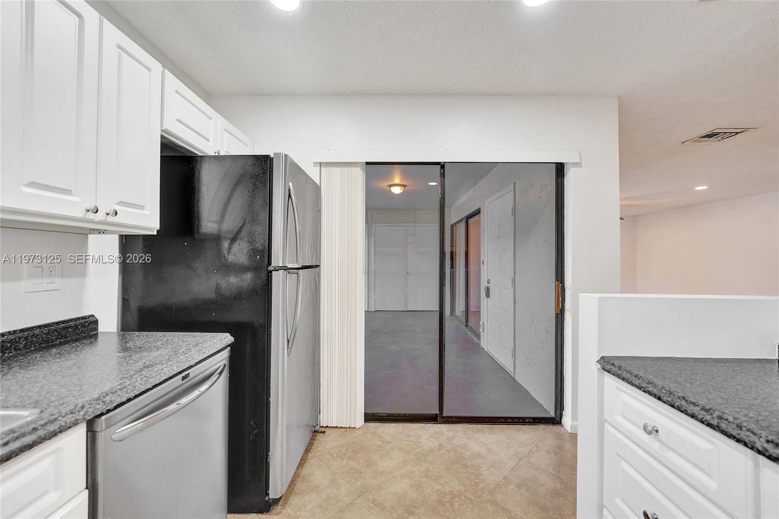 9340 Southwest 61st Way, Unit B Boca Raton, FL 33428 - Photo 8 of 25 a kitchen with stainless steel appliances granite countertop a refrigerator and a stove