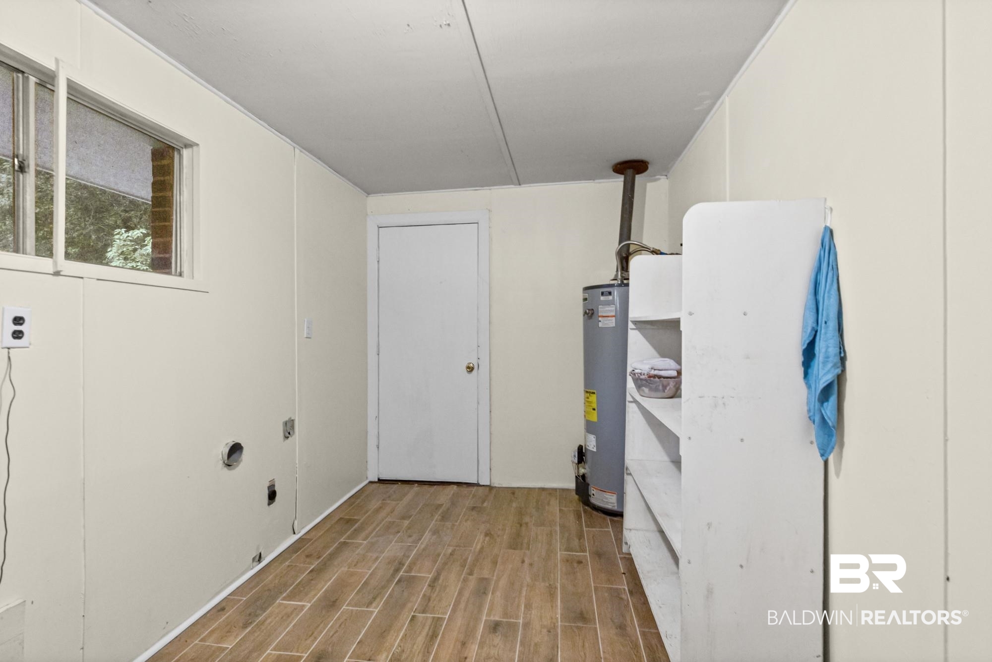 312 Sutherland Drive Mobile, AL 36611 - Photo 23 of 28 Utility room featuring wood-finish flooring, white paneling, and a window
