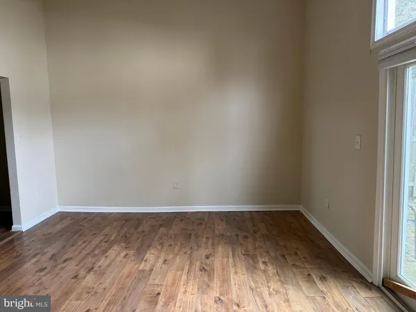 a view of an empty room with closet and entryway