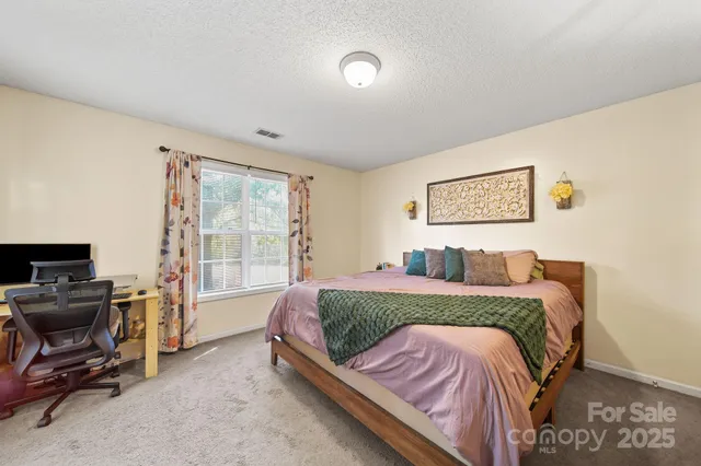 a kitchen with stainless steel appliances granite countertop a stove top oven a sink dishwasher and white cabinets with wooden floor