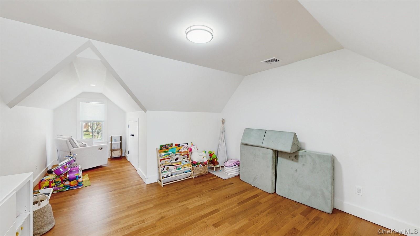 170 Wetherill Road Garden City, NY 11530 - Photo 15 of 23 Playroom with light wood-type flooring, baseboards, vaulted ceiling, and visible vents