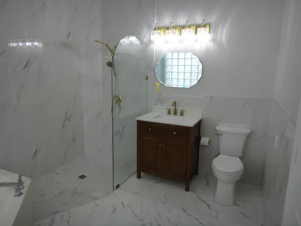 a bathroom with a toilet a sink and mirror