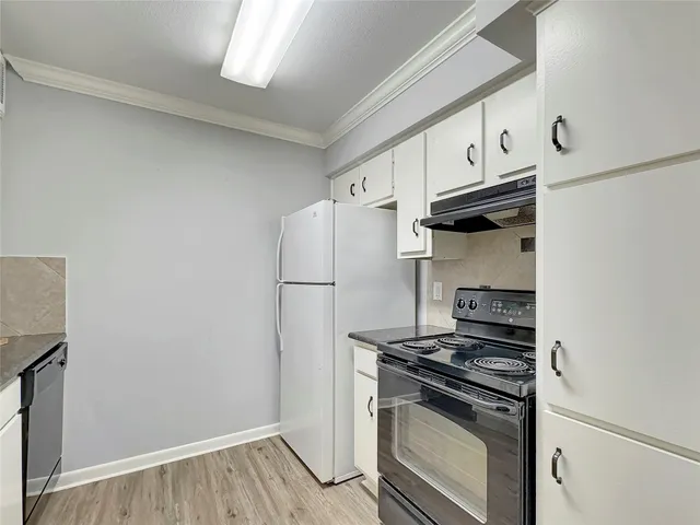 a kitchen with white cabinets and a stove top oven
