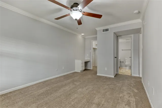 an empty room with closet and a ceiling fan