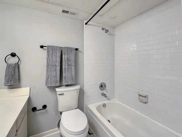 a white toilet sitting next to a bath tub
