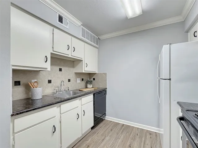 a kitchen with granite countertop white cabinets and white appliances