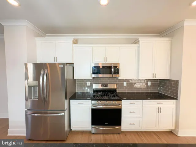 a kitchen with stainless steel appliances granite countertop a refrigerator stove and microwave