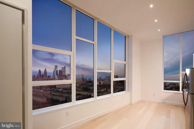 a view of a hallway with wooden floor and windows