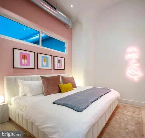 a bedroom with a bed and a painting on the wall