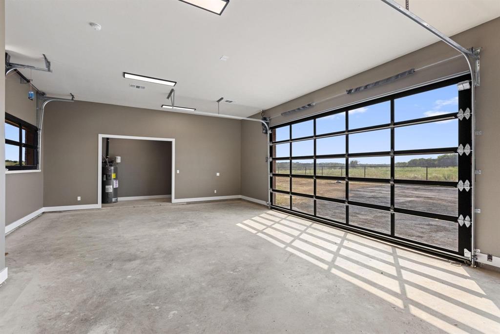 6505 County Road 1126B Godley, TX 76044 - Photo 36 of 39 Garage featuring electric water heater andbaseboards