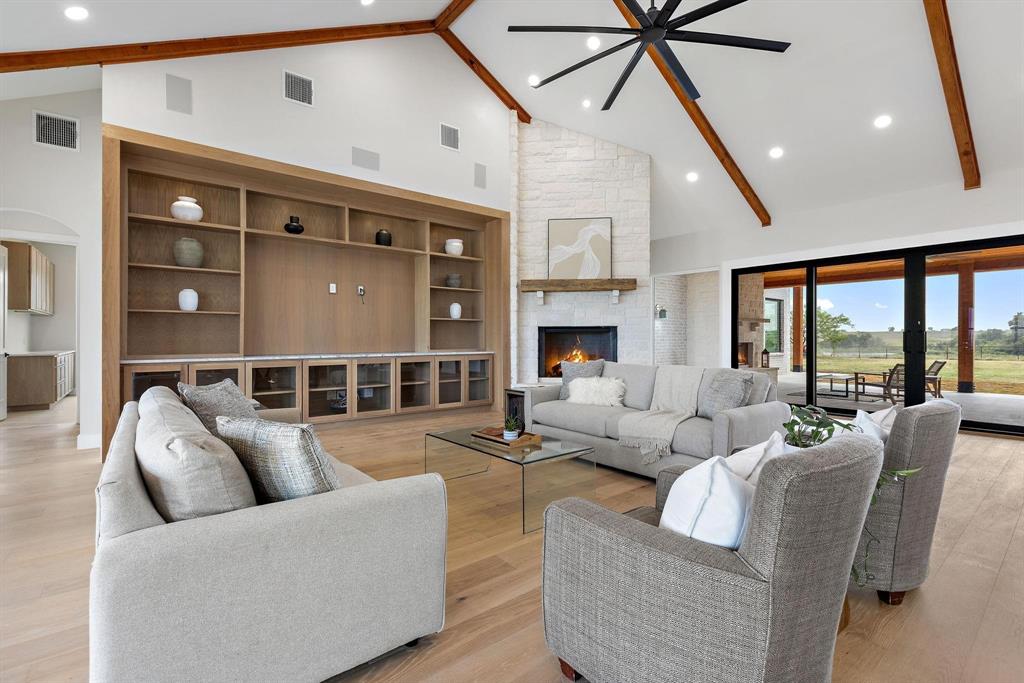 6505 County Road 1126B Godley, TX 76044 - Photo 5 of 39 Living room featuring high vaulted ceiling, lightwood-type flooring, beamed ceiling, a stonefireplace, and recessed lightingwood-type flooring, beamed ceiling, a stonefireplace, and recessed lighting