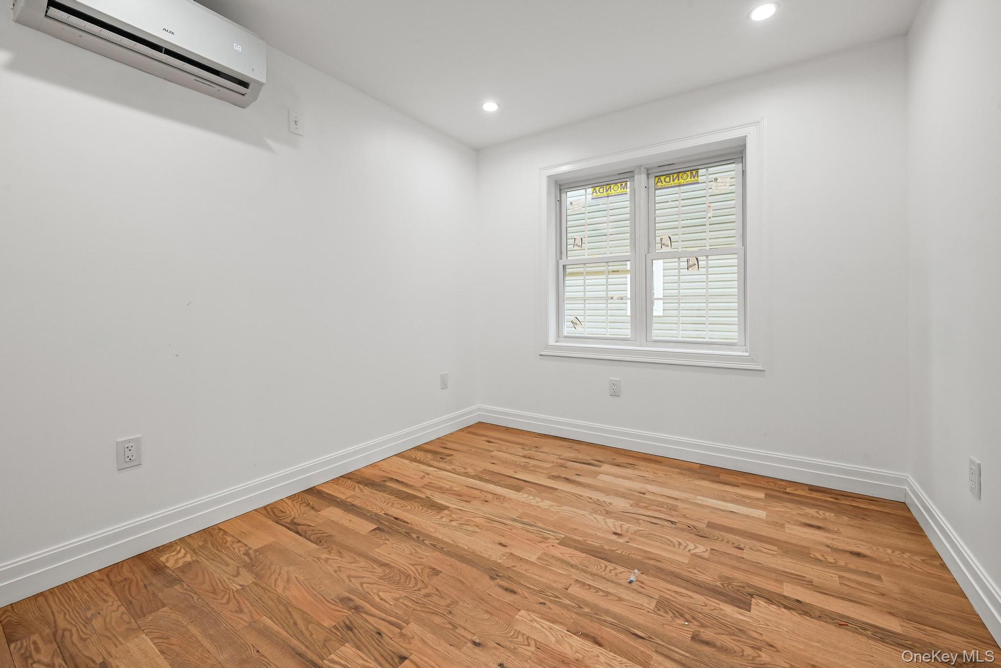 160-15 118th Road Queens, NY 11434 - Photo 7 of 23 a view of an empty room with wooden floor and a window