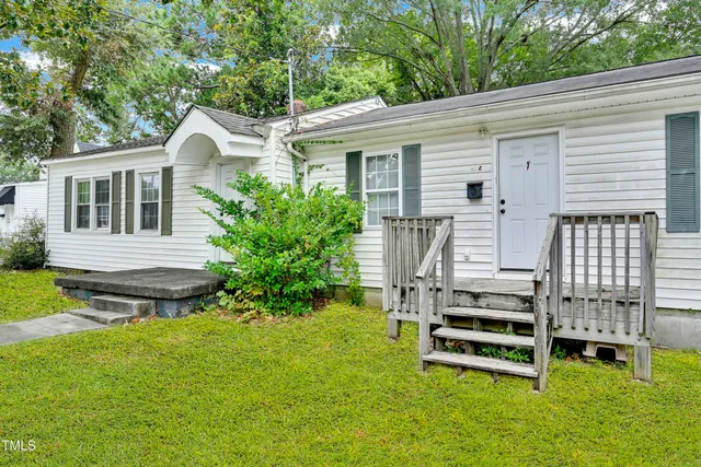 a backyard of a house with table and chairs