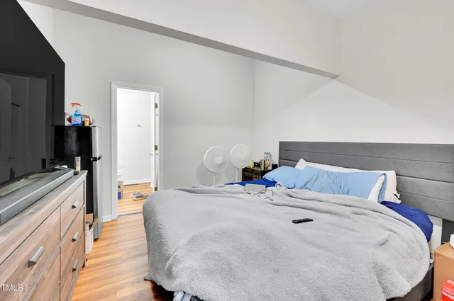 a bedroom with a bed and a large mirror on the dresser