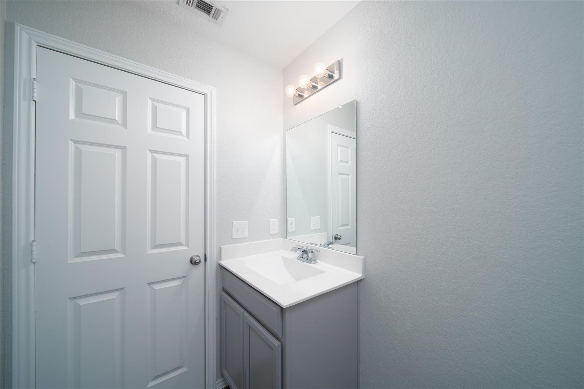24023 Swather Way Hockley, TX 77447 - Photo 23 of 26 a bathroom with a sink and a mirror