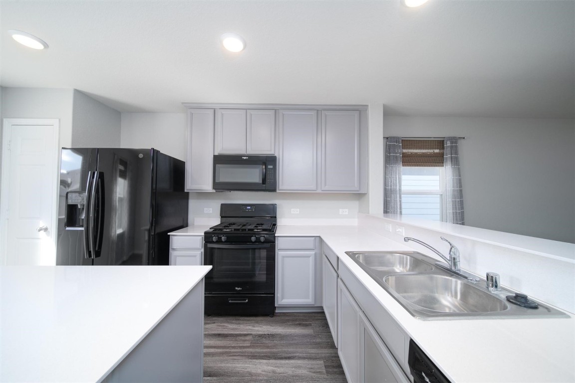 24023 Swather Way Hockley, TX 77447 - Photo 7 of 26 a kitchen with a refrigerator stove and sink