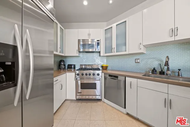 a kitchen with stainless steel appliances granite countertop a refrigerator sink and cabinets