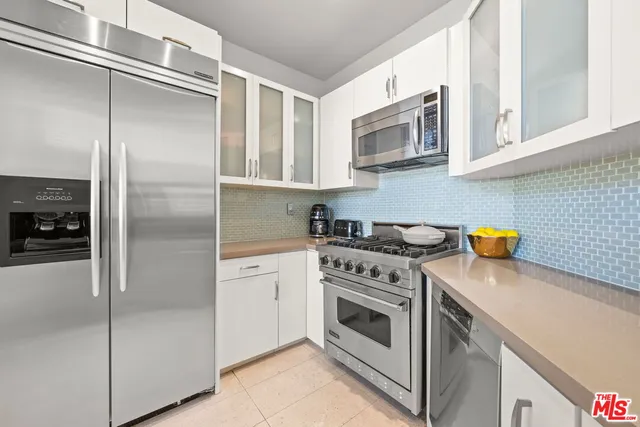a kitchen with stainless steel appliances granite countertop a refrigerator and a stove