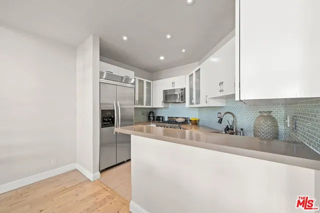 a kitchen with stainless steel appliances granite countertop a sink refrigerator and cabinets