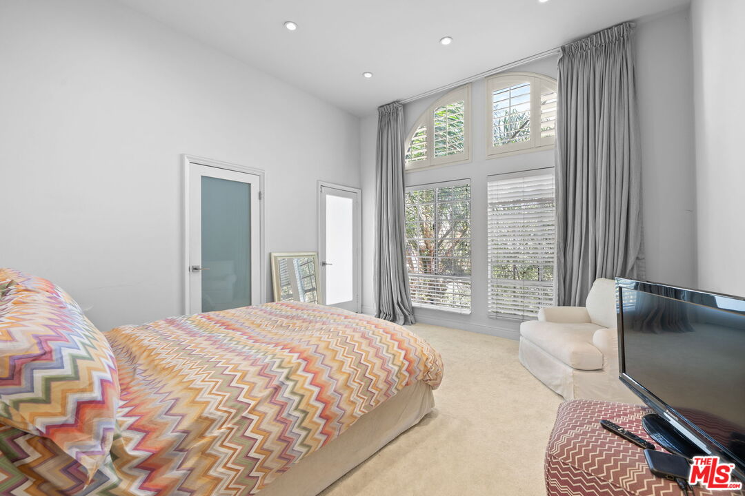 11822 Goshen Avenue, Unit 301 Los Angeles, CA 90049 - Photo 15 of 29 a bedroom with a bed and glass window