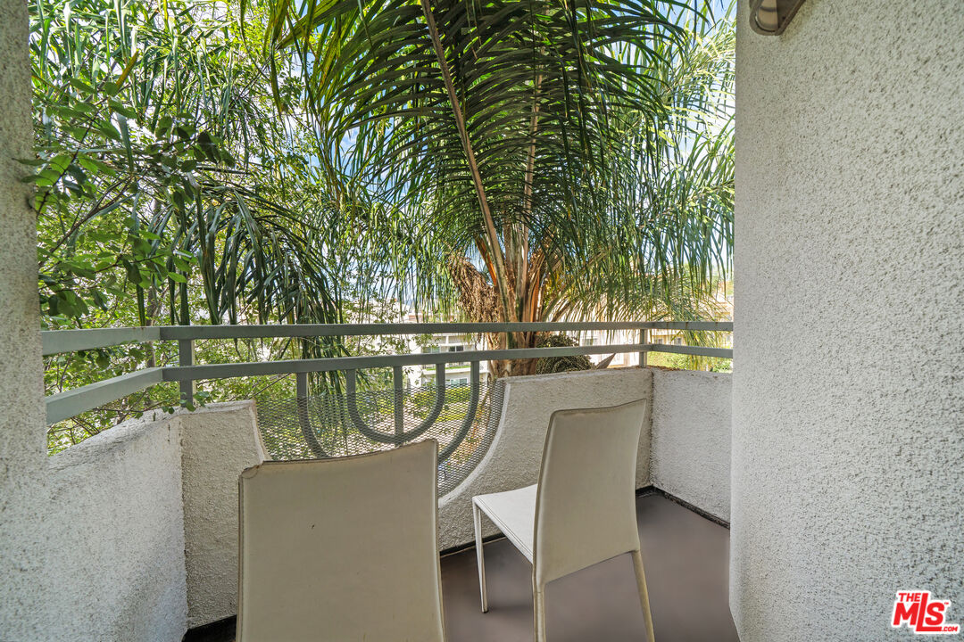 11822 Goshen Avenue, Unit 301 Los Angeles, CA 90049 - Photo 16 of 29 a balcony with table and chairs