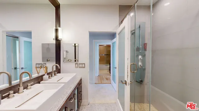 a bathroom with a double vanity sink a mirror and a shower