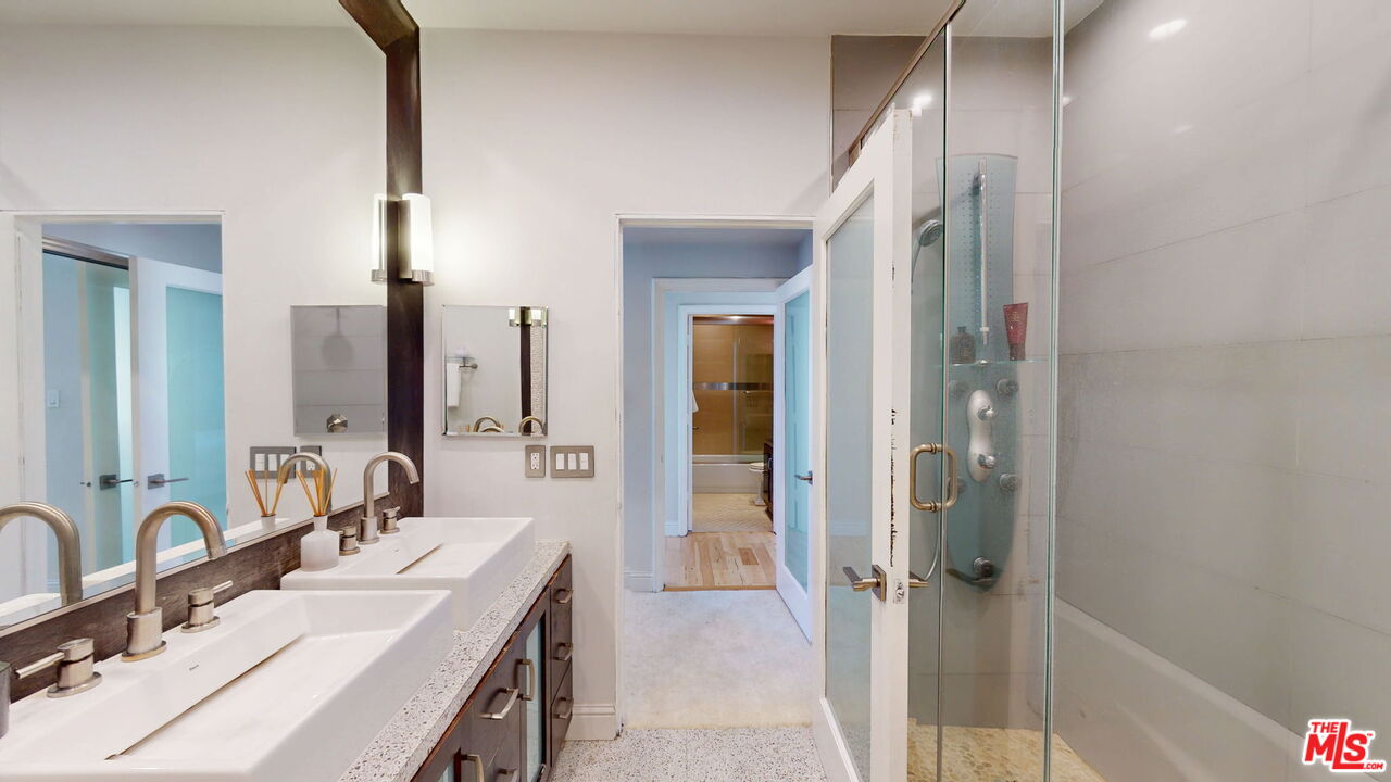 11822 Goshen Avenue, Unit 301 Los Angeles, CA 90049 - Photo 18 of 29 a bathroom with a double vanity sink a mirror and a shower