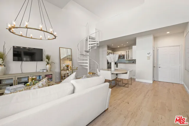 a living room with furniture a flat screen tv and kitchen view