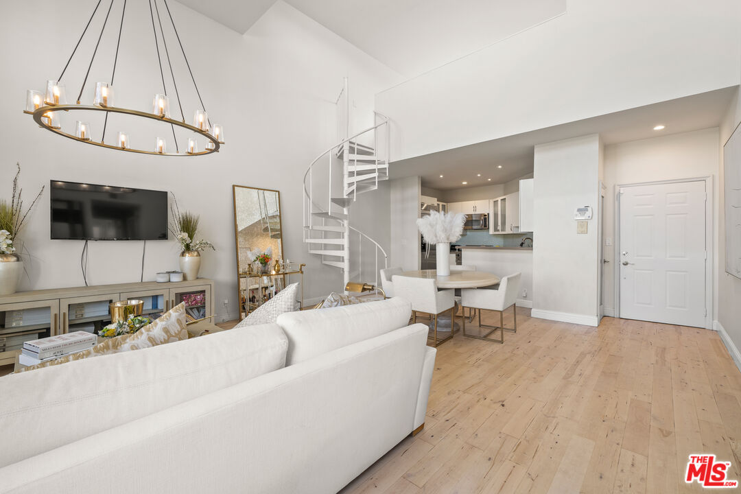 11822 Goshen Avenue, Unit 301 Los Angeles, CA 90049 - Photo 4 of 29 a living room with furniture a flat screen tv and kitchen view