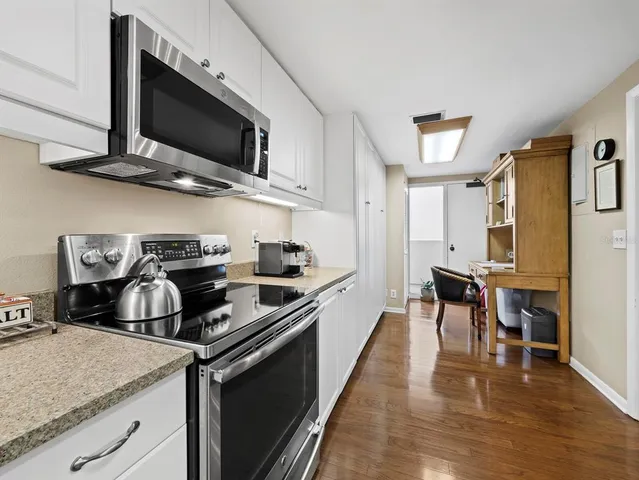 a kitchen with stainless steel appliances granite countertop a sink a stove a refrigerator and cabinets