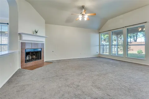 wooden floor fireplace and windows in an empty room