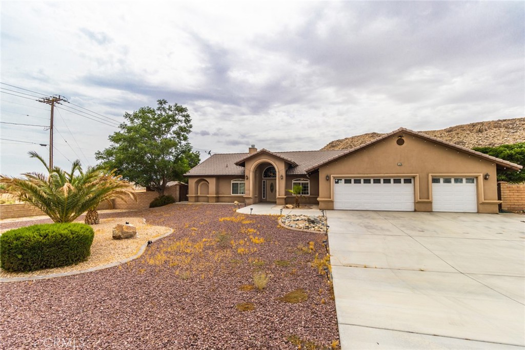 15708 Potomac Road Apple Valley, CA 92307 - Photo 1 of 1 a front view of a house with a yard and garage