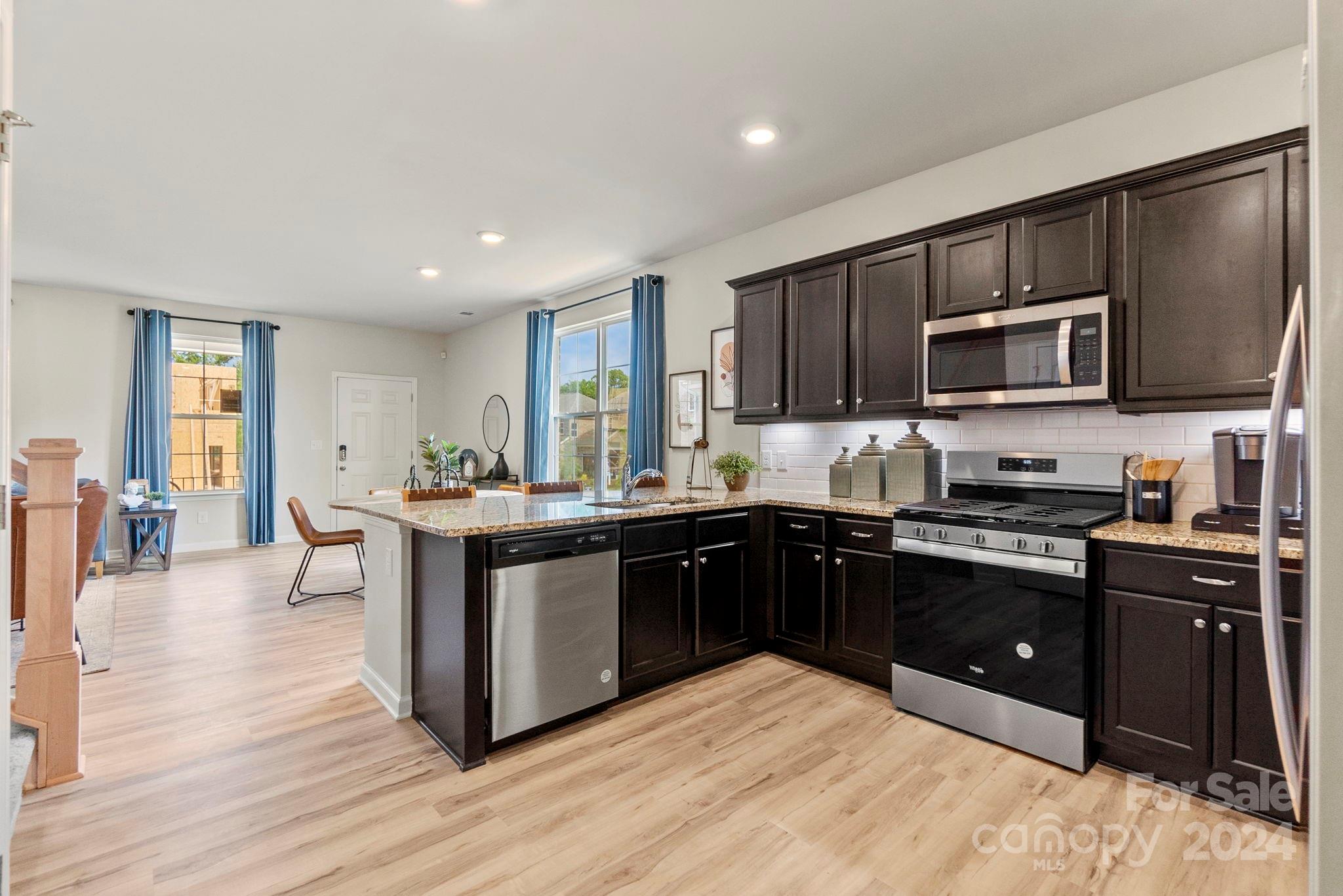 7902 Nelson Road Mint Hill, NC 28227 - Photo 9 of 30 a kitchen with stainless steel appliances kitchen island granite countertop a stove top oven and sink