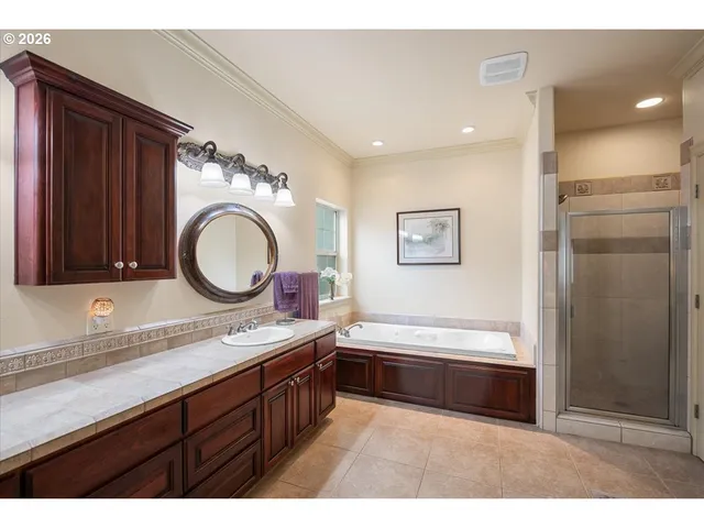a bathroom with a tub sink double vanity granite and a mirror